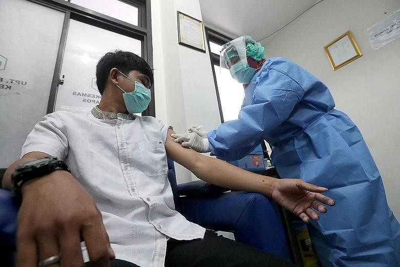 Motorcycle-taxi driver Fadly Barjadi Kusuma and his wife are taking part in the clinical trial for Sinovac Biotech's vaccine. ST PHOTO: WAHYUDI SOERIAATMADJA A participant receiving an injection during a Covid-19 immunisation simulation exercise last