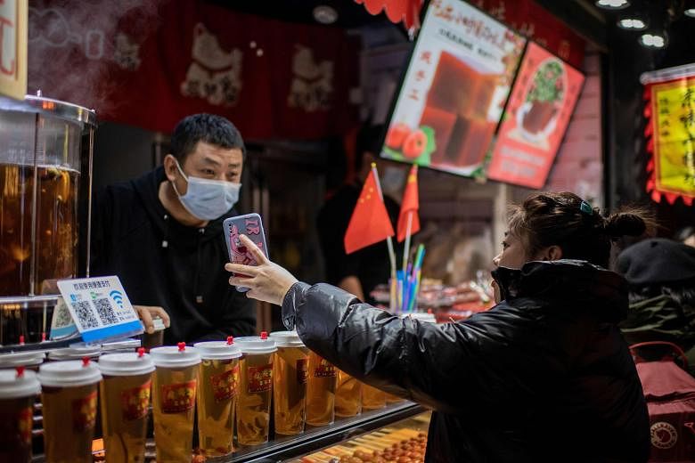 A customer displaying her Alipay electronic payment confirmation to an employee at a beverage shop in Beijing on Wednesday. China has revolutionised e-commerce and has raced ahead in the fields of artificial intelligence and 5G development, among its