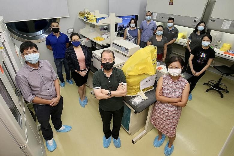 Associate Professor Tan Boon Huan (front row, right), director of DSO National Laboratories' biological defence programme, with members of her winning team at a DSO lab in Kent Ridge. She said her team's role in the national Covid-19 effort was the r