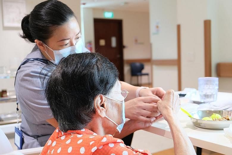 To overcome manpower constraints amid Covid-19, The Salvation Army Peacehaven Nursing Home employed staff from SG Healthcare Corps, such as this senior care associate (above). A client at social service agency Awwa being reassessed by a staff member 