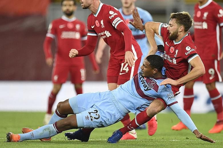 Liverpool's Nathaniel Phillips (right) tackling West Ham's Sebastien Haller during their Premier League match on Saturday. The Reds won 2-1 thanks to Mohamed Salah's penalty and Diogo Jota's late strike.