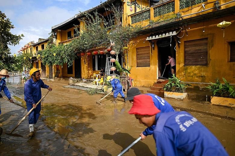 Municipal workers cleaning up the streets of Hoi An after waters receded last week. Popular heritage sites such as Hoi An in Quang Nam province and Hue Imperial Citadel in Thua Thien Hue province are among the casualties of the typhoon season. PHOTO:
