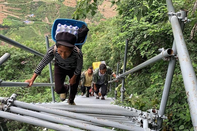 Villagers climbing a series of steel stairs and ladders (above) to reach their homes in the village of Atulie'er (left) in Liangshan Yi Autonomous Prefecture in Sichuan province. Officials acknowledge that the pandemic has badly affected the prefectu