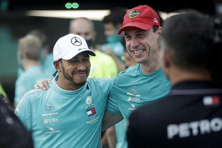 Above: Lewis Hamilton and his team celebrating in the pits after Mercedes won their seventh straight F1 constructors' title at Imola on Sunday. Left: Hamilton and team principal Toto Wolff in high spirits.