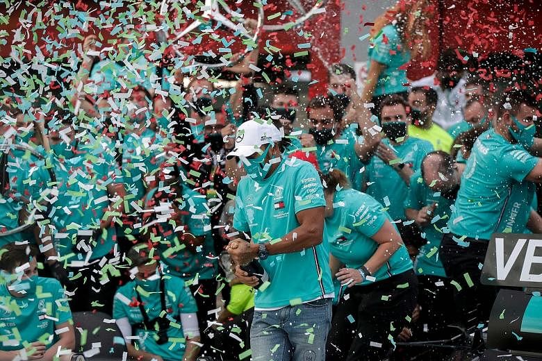 Above: Lewis Hamilton and his team celebrating in the pits after Mercedes won their seventh straight F1 constructors' title at Imola on Sunday. Left: Hamilton and team principal Toto Wolff in high spirits.