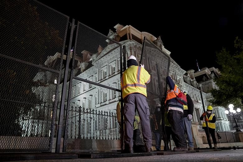 Construction workers setting up additional fencing near the White House in Washington on Monday. Shops and other businesses located nearby have closed and some will remain shuttered for the rest of the week.