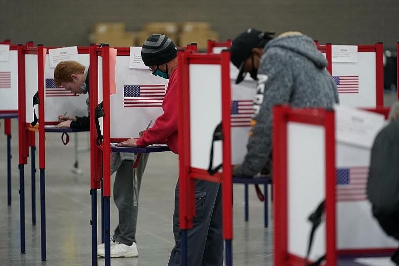 Voters filling in their ballots at the Kentucky Exposition Centre in Louisville yesterday. The results of the United States presidential election may take days or weeks, due to the record number of mail-in ballots.