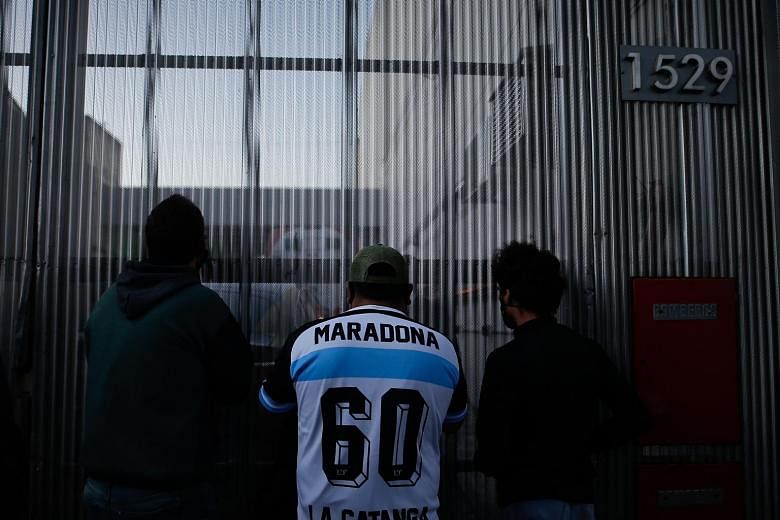Fans of Argentina football legend Diego Maradona gather outside the Olivos Clinic in the province of Buenos Aires, where he arrived for surgery on Tuesday. The 1986 World Cup winner, who celebrated his 60th birthday last Friday, is in recovery after 