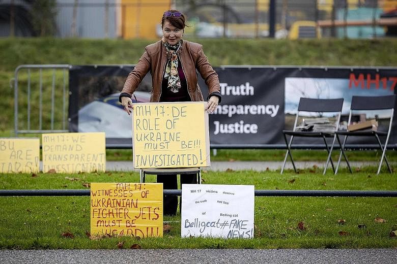 A pro-Russian protester holding a placard outside Schiphol Judicial Complex, in the Netherlands, where the trial on the 2014 downing of the Malaysia Airlines jet continues. All 298 people on board were killed.