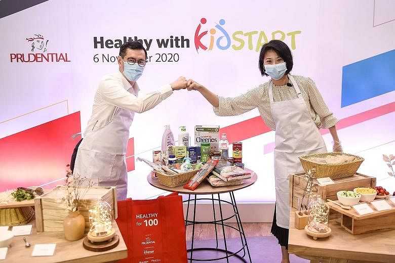 Minister of State for Social and Family Development and Education Sun Xueling and Prudential Singapore's chief executive Dennis Tan taking part in a cook-off session at the launch of the Healthy with KidStart programme yesterday. PHOTO: PRUDENTIAL SI