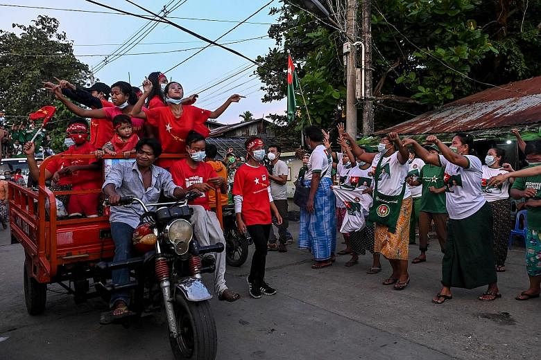 National League for Democracy supporters riding a trishaw decorated with party flags and images of Myanmar State Counsellor Aung San Suu Kyi outside Yangon on Friday. National League for Democracy (NLD) party supporters (in red) passing supporters of