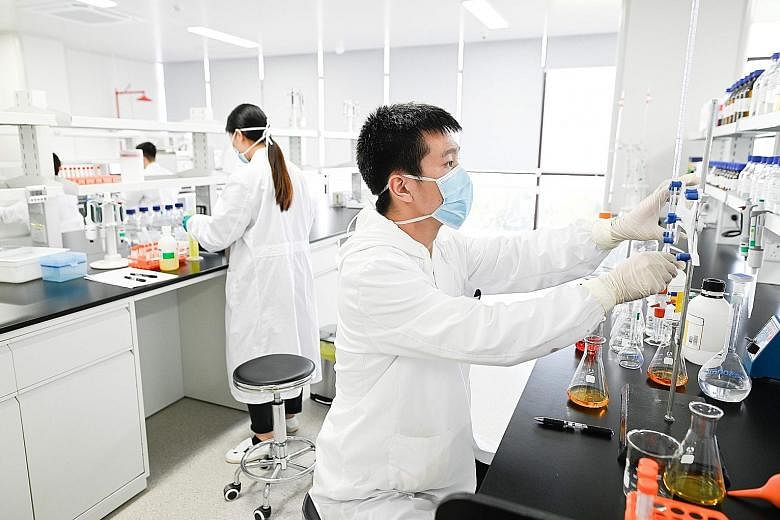 Lab workers at a new Sinovac factory in Beijing built to produce a Covid-19 vaccine. Sinovac is one of 11 Chinese companies approved to carry out clinical trials of potential vaccines for the coronavirus. PHOTO: AGENCE FRANCE-PRESSE