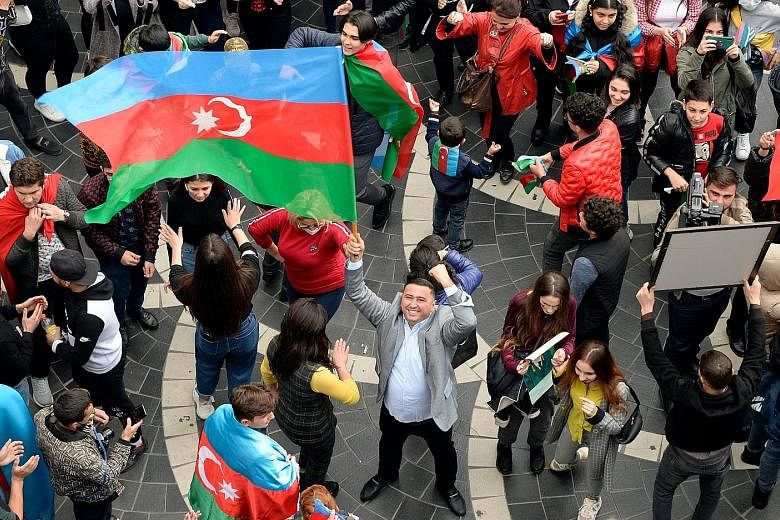Azerbaijanis celebrating in the streets of the capital Baku on Tuesday after the peace deal was reached. The country reclaimed 15 per cent to 20 per cent of its lost territory during the recent conflict. PHOTO: AGENCE FRANCE-PRESSE