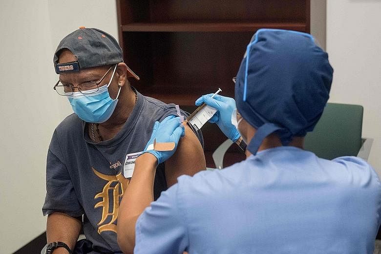 A volunteer being given a shot at Moderna's vaccine trial on Aug 5 in Detroit, Michigan. The firm's interim analysis of the shot's effectiveness could come within days amid an explosion of Covid-19 cases in the US.