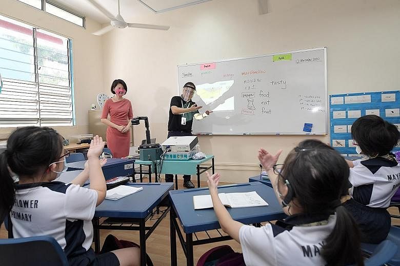 Minister of State for Education Sun Xueling watching as specialised teacher David Lee conducted a class yesterday at Mayflower Primary School. Besides having a dedicated sign language teacher, children will have access to external speech and language