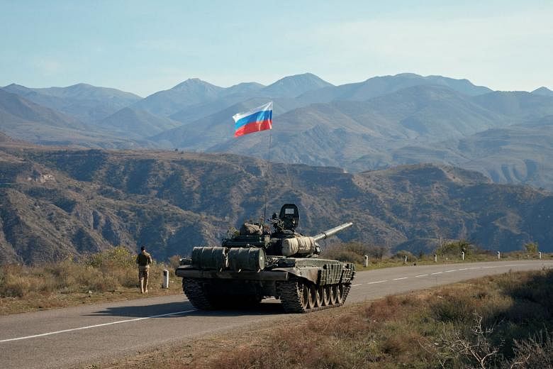 A Russian peacekeeper next to a tank in the region of Nagorno-Karabakh on Tuesday, following the signing of a deal to end the military conflict between Azerbaijan and ethnic Armenian forces. The ceasefire deal sparked off mass anti-government demonst