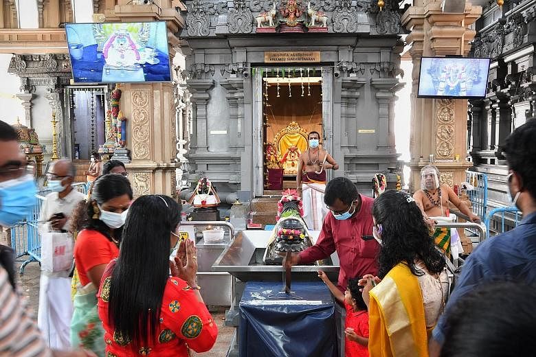 Masked devotees offering their prayers at Sri Thendayuthapani Temple yesterday. Mr Raja Segar, the Hindu Endowments Board's chief executive officer, said: "People understand the current situation... But some of them felt that they should spend a shor