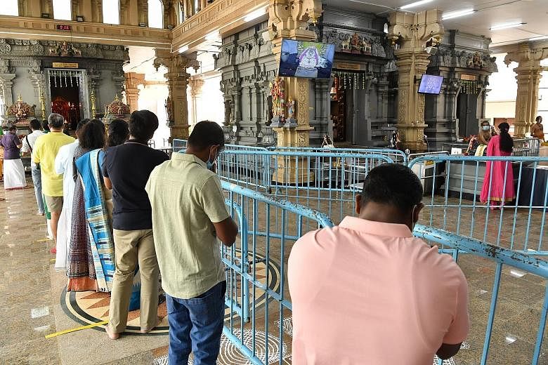 Visitors at Sri Thendayuthapani Temple maintaining a safe distance while offering prayers. They also had to follow a barricade system which directed the flow of devotees.