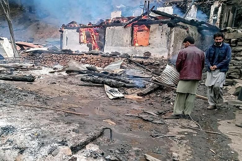 Residents at the scene of devastation following cross-border shelling between Pakistani and Indian forces in Tehjain village at the Line of Control in Neelum Valley of Pakistan-administered Kashmir on Friday.