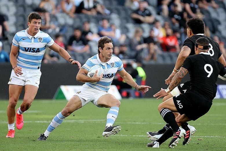 Argentina's Nicolas Sanchez trying to evade a tackle in the Tri-Nations rugby match against New Zealand in Sydney yesterday. The fly-half converted his own try and scored six penalties in the historic 25-15 win.