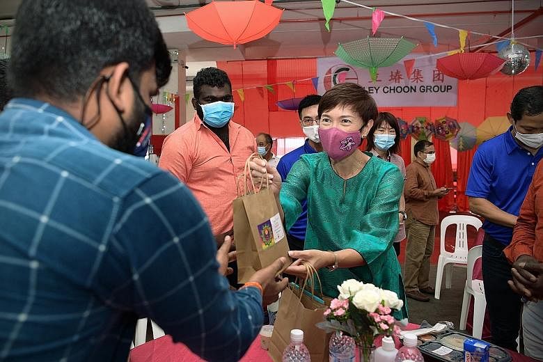 Manpower Minister Josephine Teo distributing goodie bags to migrant workers at a factory-converted dorm in Sungei Kadut yesterday. ST PHOTO: NG SOR LUAN