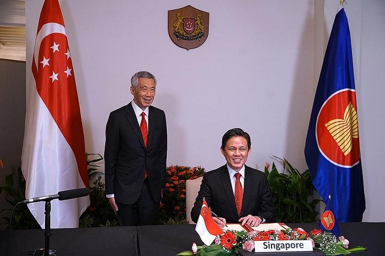 Prime Minister Lee Hsien Loong witnessing the signing of the Regional Comprehensive Economic Partnership (RCEP) agreement by Trade and Industry Minister Chan Chun Sing yesterday. The trade pact was signed virtually by all 10 Asean members and key par