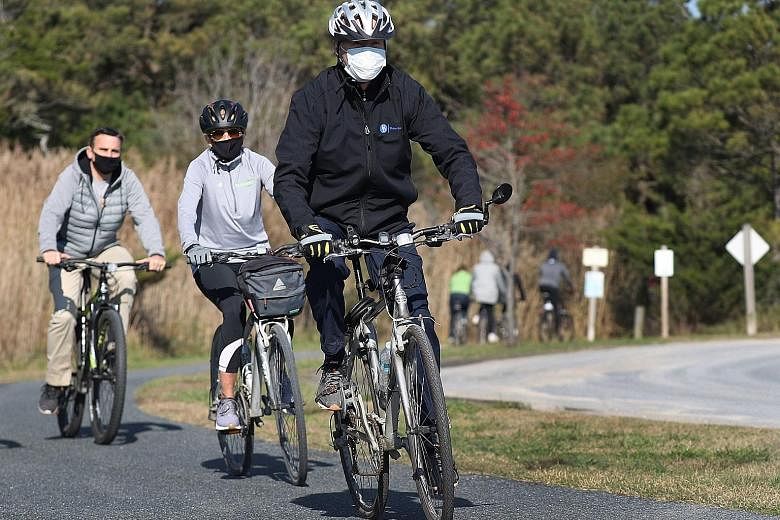 US President-elect Joe Biden and his wife, Jill Biden, cycling in Cape Henlopen State Park, Delaware, last Saturday. Observers expect Washington under Mr Biden to re-engage with the international community, and to resume discussions on some issues bl