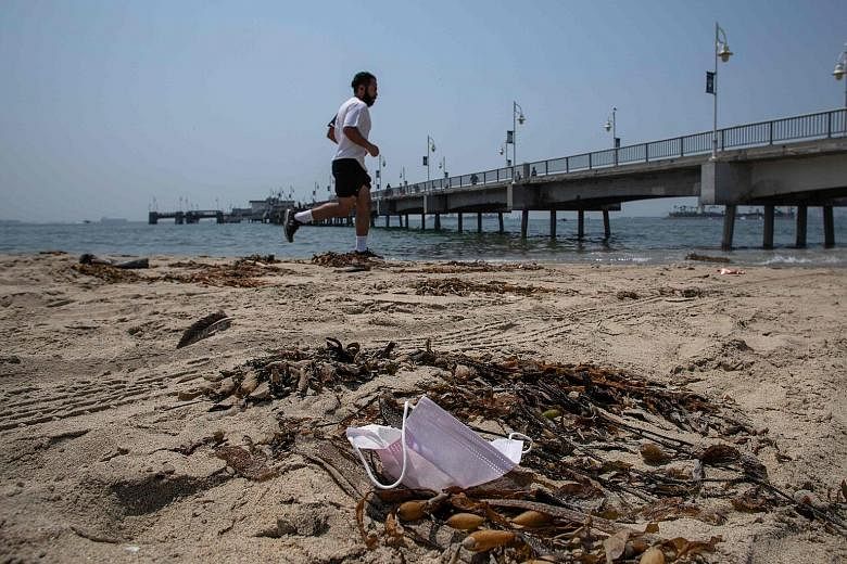 A discarded surgical mask in Long Beach, California. As mask usage increases, the fact that so many disposable plastic masks wind up in the oceans has become an environmental issue.