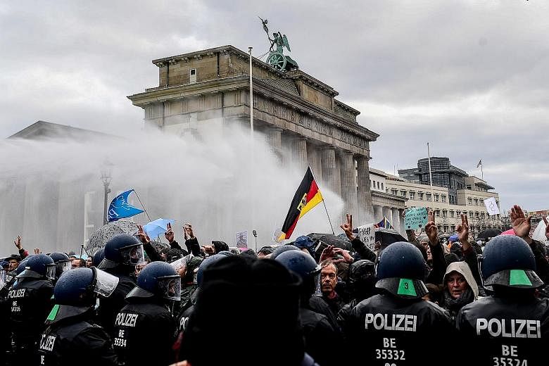 Riot police using a water cannon to break up a demonstration against Germany's coronavirus restrictions, near Berlin's Brandenburg Gate, on Wednesday. Two weeks into a partial shutdown, contagion rates in the country are still nearly triple the level