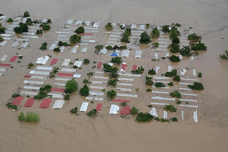 HONDURAS Above: An area around San Pedro Sula flooded by the overflowing Chamelecon river after the passage of Iota on Wednesday. NICARAGUA Far left: A photo from Catholic Relief Services showing a man standing in a house damaged by Iota in Puerto Ca