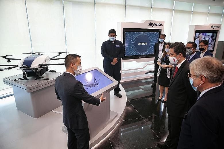 Trade and Industry Minister Chan Chun Sing being given a tour of the Airbus Singapore Campus' Digital Experience Centre yesterday, accompanied by Airbus chief commercial officer and head of international Christian Scherer (right). The campus consolid