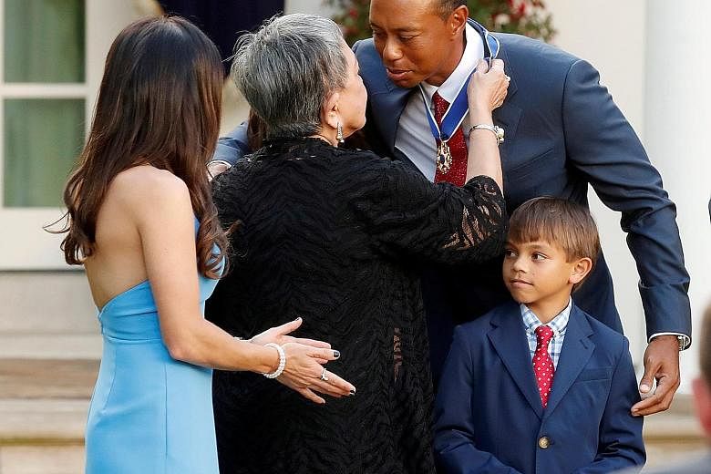 Tiger Woods is embraced by his mother Kultida after being presented with the Presidential Medal of Freedom, the US' highest civilian honour, in May last year as his son Charlie looked on in the White House Rose Garden.