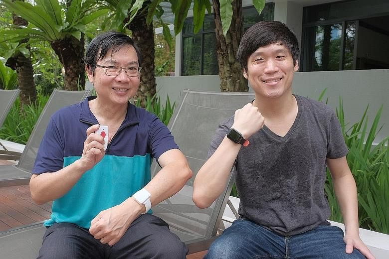 SenzeHub founder and chief executive George Heng (in blue-green top) and chief marketing officer Andrew Schill posing with the Internet-of-Things-enabled watches. These monitor patients' vital signs such as heart rate and temperature. ST PHOTO: GAVIN