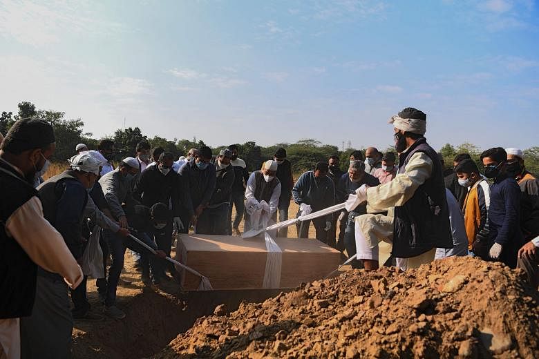 Relatives and graveyard workers preparing to lower the coffin of a Covid-19 victim at a graveyard in New Delhi on Tuesday. India - the world's second worst-hit country in terms of the number of Covid-19 cases - has now also registered more than 132,0