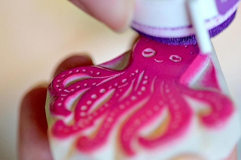 Ms Rachel Ma inking an octopus stamp for printing. A full-time rubber stamp artist, she hand-carves all her stamps.