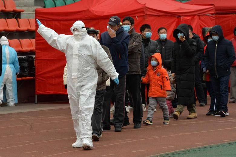 A Chinese government worker leading a group of citizens to take swab samples for the Covid-19 test in Tianjin yesterday, under a three-day screening programme for nearly three million of its residents.