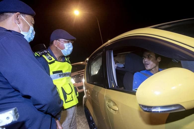 Kelantan police chief Shafien Mamat (second from left) advising a motorist to adhere to the conditional movement control order during his walkabout at roadblocks set up in Pulai Chondong in Kelantan yesterday.