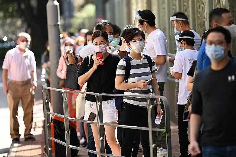 People queueing outside a coronavirus testing centre in Hong Kong yesterday, as a spike in Covid-19 cases brought about tighter restrictions. Under the Hong Kong government's new rules, anyone who fails to comply with a Covid-19 testing notice may be