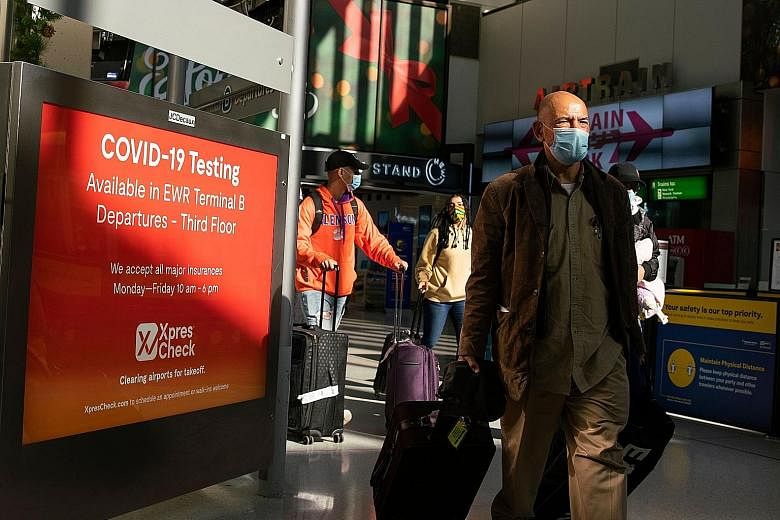 Travellers at Newark International Airport in New Jersey on Saturday. US health officials have warned that the burgeoning wave of infections could soon overwhelm the healthcare system if people do not follow public health guidance, particularly aroun