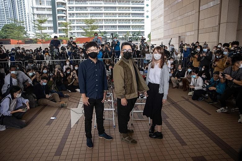Pro-democracy activists (from far left) Joshua Wong, Ivan Lam and Agnes Chow outside the West Kowloon Law Courts building in Hong Kong yesterday, before they were charged with inciting an unauthorised assembly during last year's anti-government prote