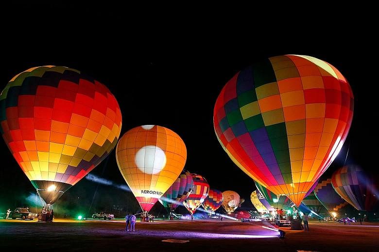 ALIGHT AT NIGHT: Balloons lit up during the "Magical Night" part of the festival. There were only a few hundred spectators on site, rather than the usual half a million, as the event was streamed online amid measures to stem the Covid-19 outbreak. LI