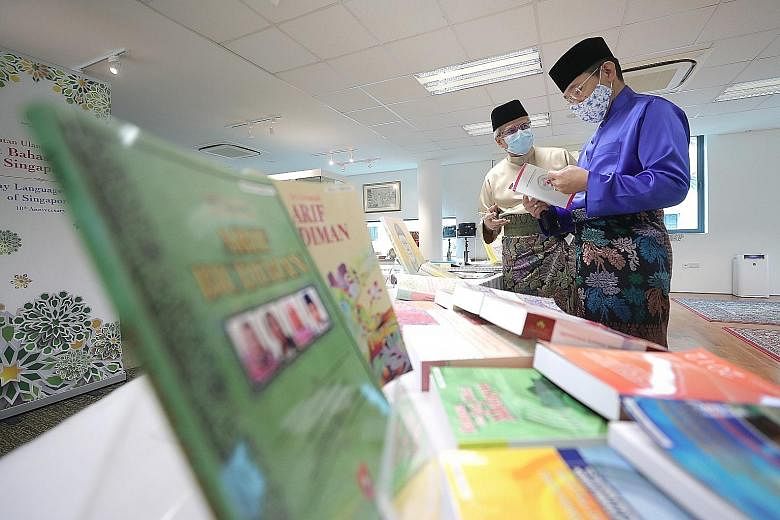 Second Minister for Education Maliki Osman (right) and Malay Language Centre of Singapore centre director Mohamed Noh Daipi looking at teaching resources at the centre yesterday as it celebrated its 10th year. ST PHOTO: GAVIN FOO