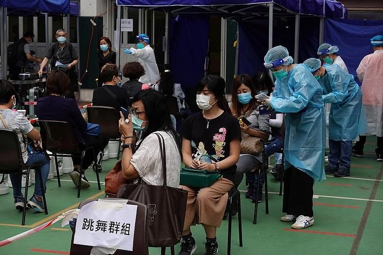 Medical workers attending to people at a makeshift community testing centre for the coronavirus in Hong Kong's Yau Tsim Mong district yesterday. The government has ordered bars, pubs, nightclubs and party rooms to shut until at least Dec 2, following