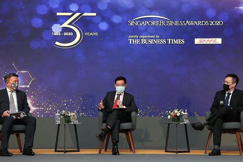 Deputy Prime Minister Heng Swee Keat speaking at the 35th Singapore Business Awards, held at Singapore Press Holdings' News Centre auditorium yesterday. His fellow panellists were DHL Express Singapore managing director Christopher Ong (left) and Bus