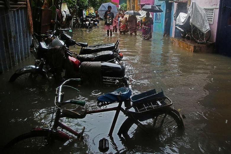 Residents gathering in a waterlogged street after rains and floods in Chennai, India, yesterday. With Cyclone Nivar set to make landfall in Tamil Nadu and Puducherry late last night, 1,200 National Disaster Response Force personnel were on alert for 