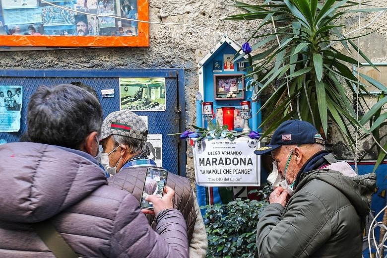 People gathering around an altar to mourn football legend Diego Maradona yesterday in the Spanish quarter of Naples, a day after his death from a heart attack in Argentina.