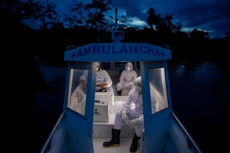 Health workers from the city of Melgaco making their way back on a boat ambulance after visiting eight families who live without electricity in a small riverside community along the Quara river in the south-west of Marajo Island, Brazil, amid concern