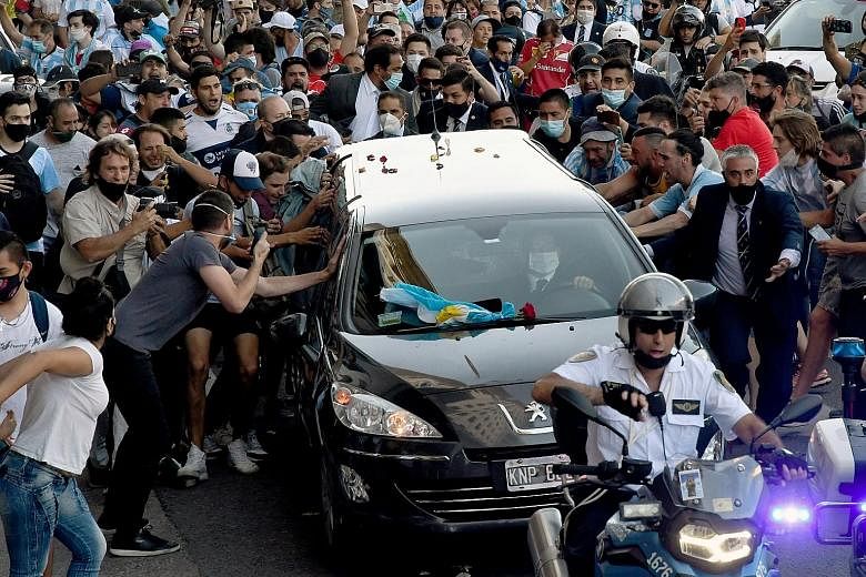 Left: Fans swarming around the hearse carrying Argentinian football legend Diego Maradona as it made its way from the Casa Rosada presidential palace in Buenos Aires to the cemetery on Thursday. Below: The hero's casket being carried at the Jardin Be