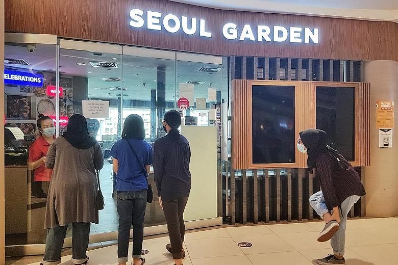 Staff from Clean Solutions, a professional cleaning company, disinfecting the interior of the Seoul Garden restaurant in Tampines Mall yesterday. Mr Garry Lam, Seoul Garden Group's general manager, said the family of 13 did not come to the restaurant