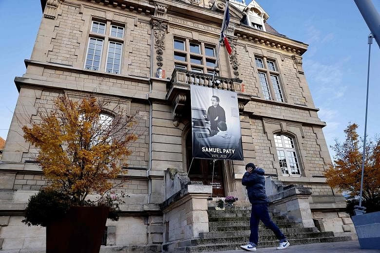 A poster of French teacher Samuel Paty on the facade of the City Hall building in Conflans-Sainte-Honorine. He was killed last month, days after showing his class caricatures of Prophet Muhammad that had been published by Charlie Hebdo a few years ag